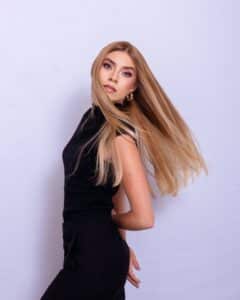 אישה עם שיער ארוך וחלק בגוון בלונד מובהר על רקע סגלגל